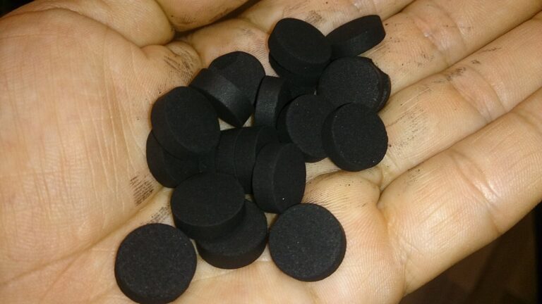 Activated Charcoal: black charcoal tablets in a hand