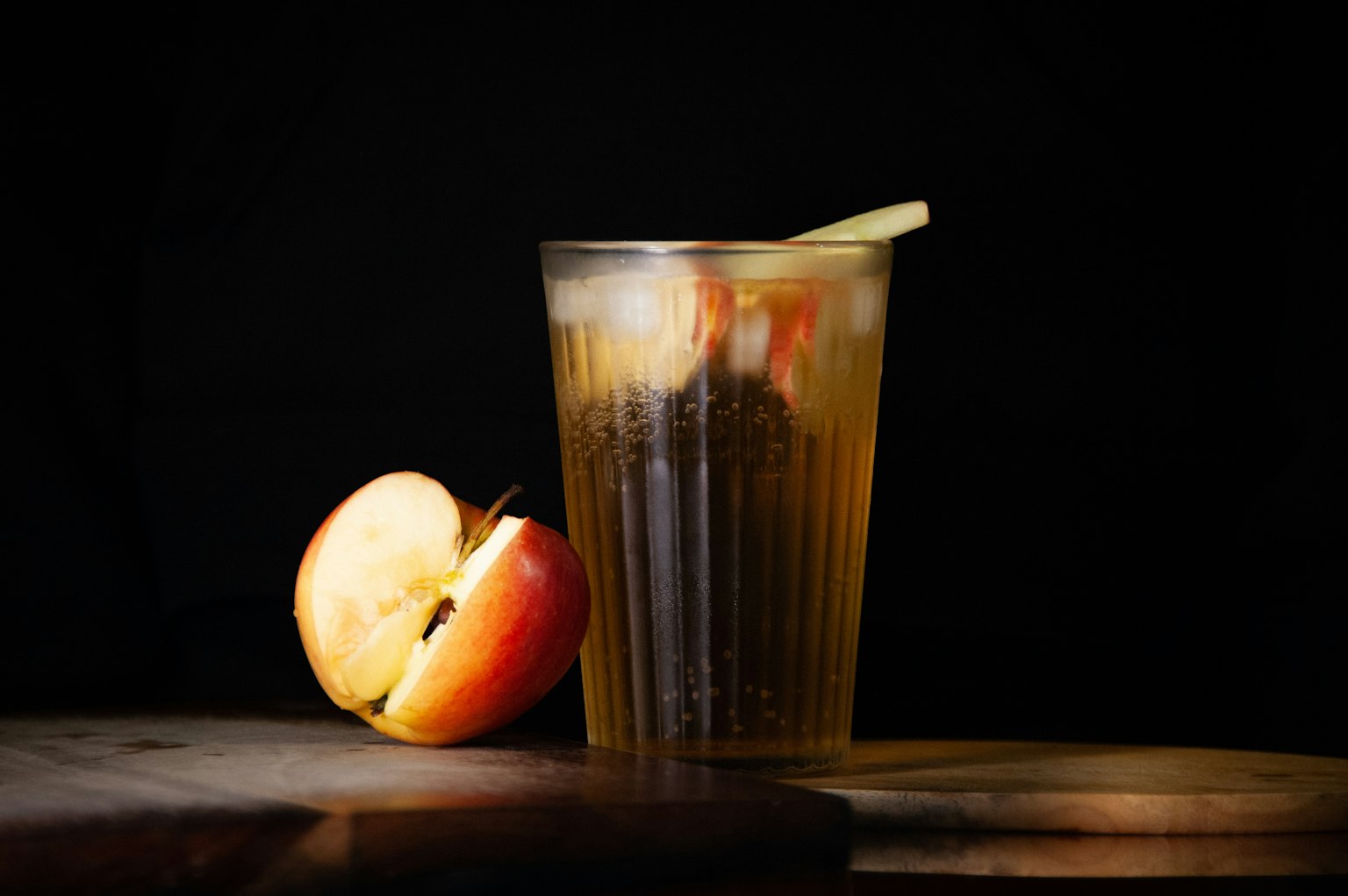 An apple beside a glass of diluted apple cider vinegar