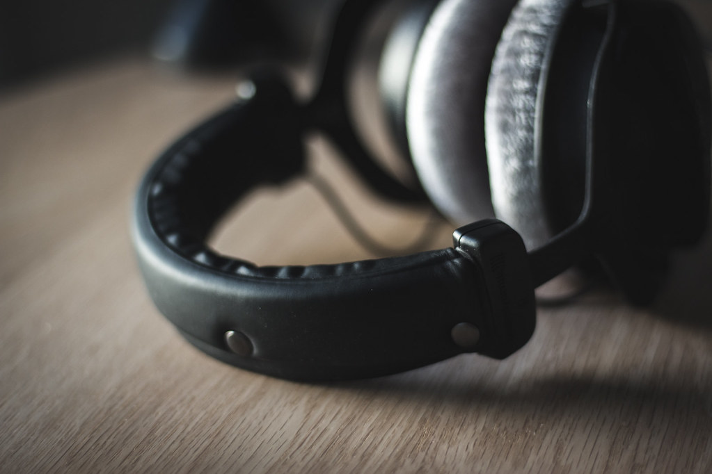 Over-ear studio headphones resting on a wooden table
