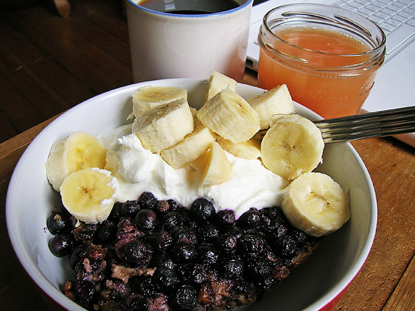 A breakfast of blueberry walnut baked oatmeal with yogurt and banana