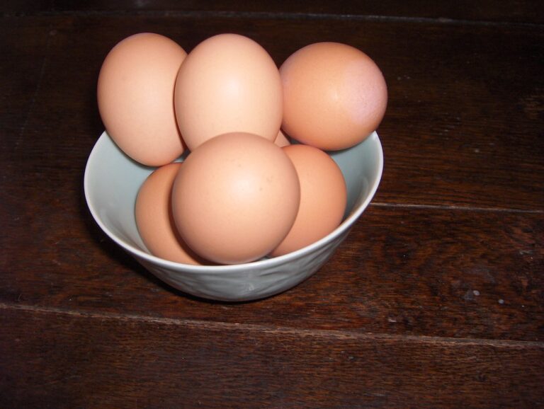 A bowl of brown eggs on a dark wooden table