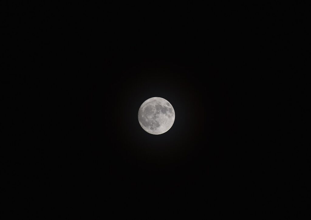 A bright full moon in a dark night sky