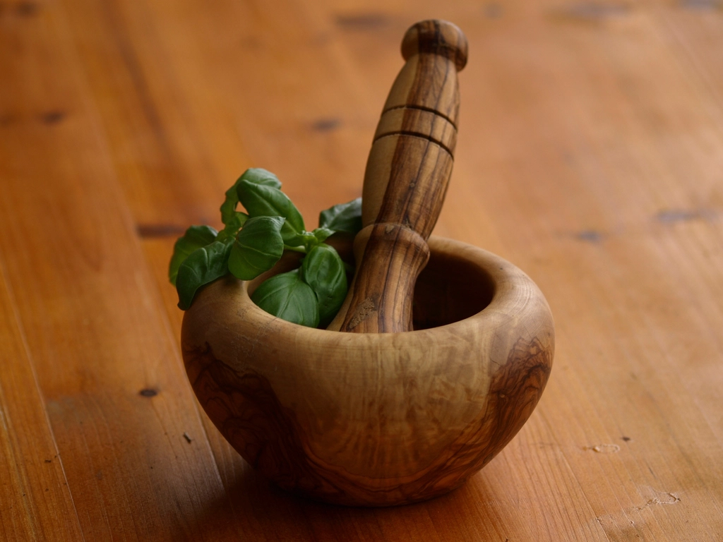 Fresh herbs in a wooden mortar and pestle