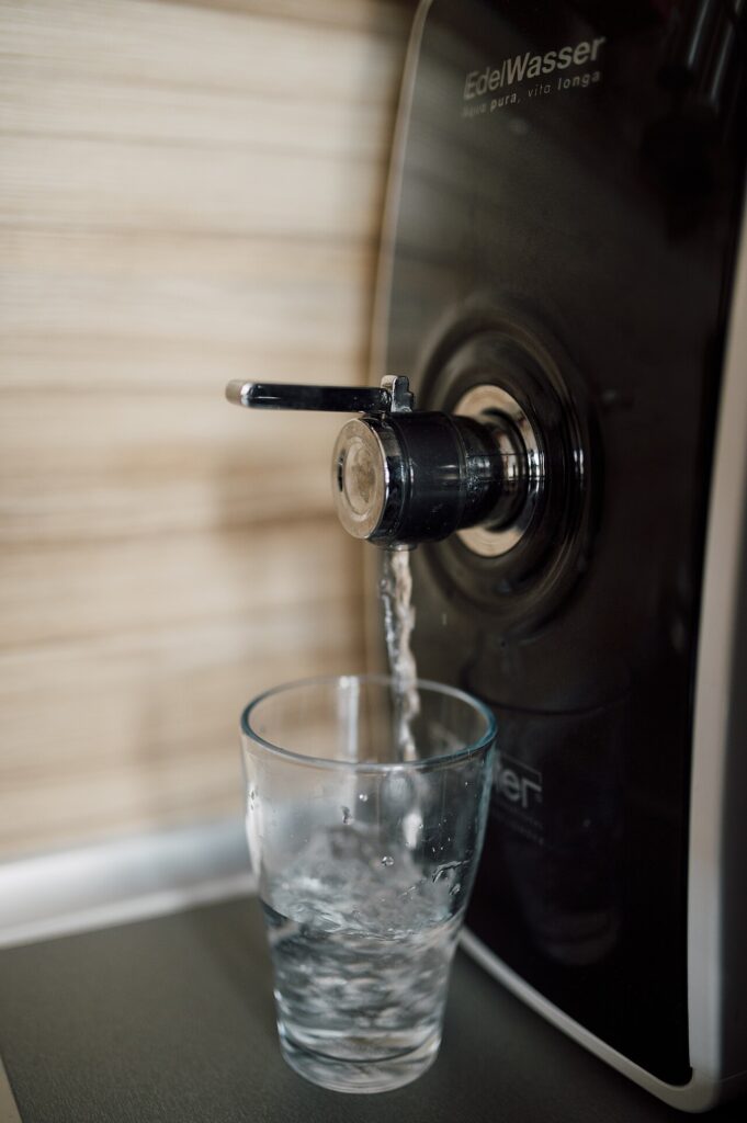 A clear glass being filled with fresh water in a kitchen