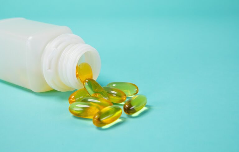 Glutathione: supplement capsules spilling from a white bottle