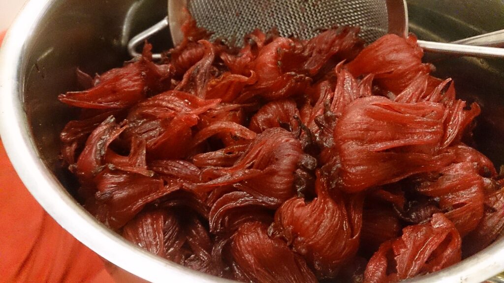 A bowl of deep red hibiscus (roselle) calyces, the part used for hibiscus tea