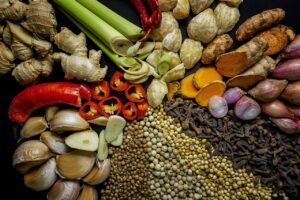 Fresh spices and roots including ginger, turmeric, garlic, chilli and peppercorns