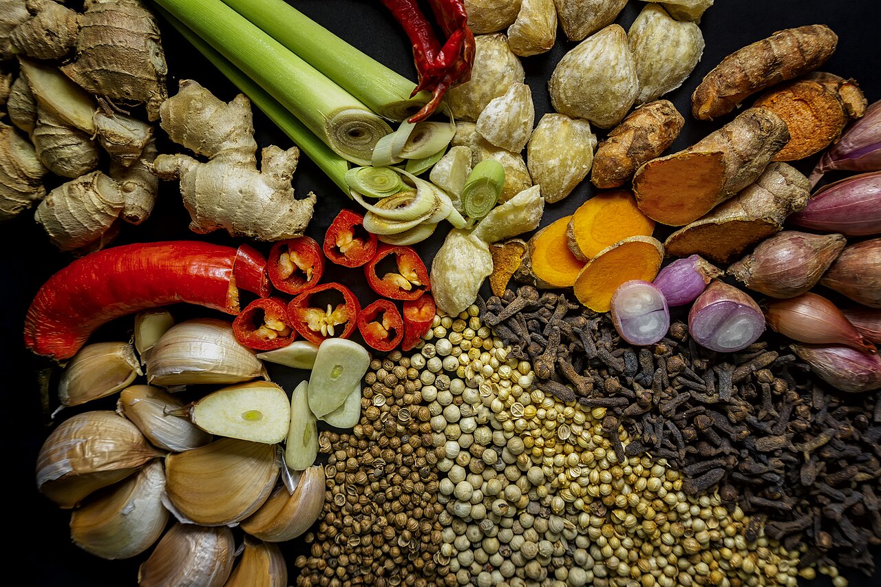 Fresh spices and roots including ginger, turmeric, garlic, chilli and peppercorns