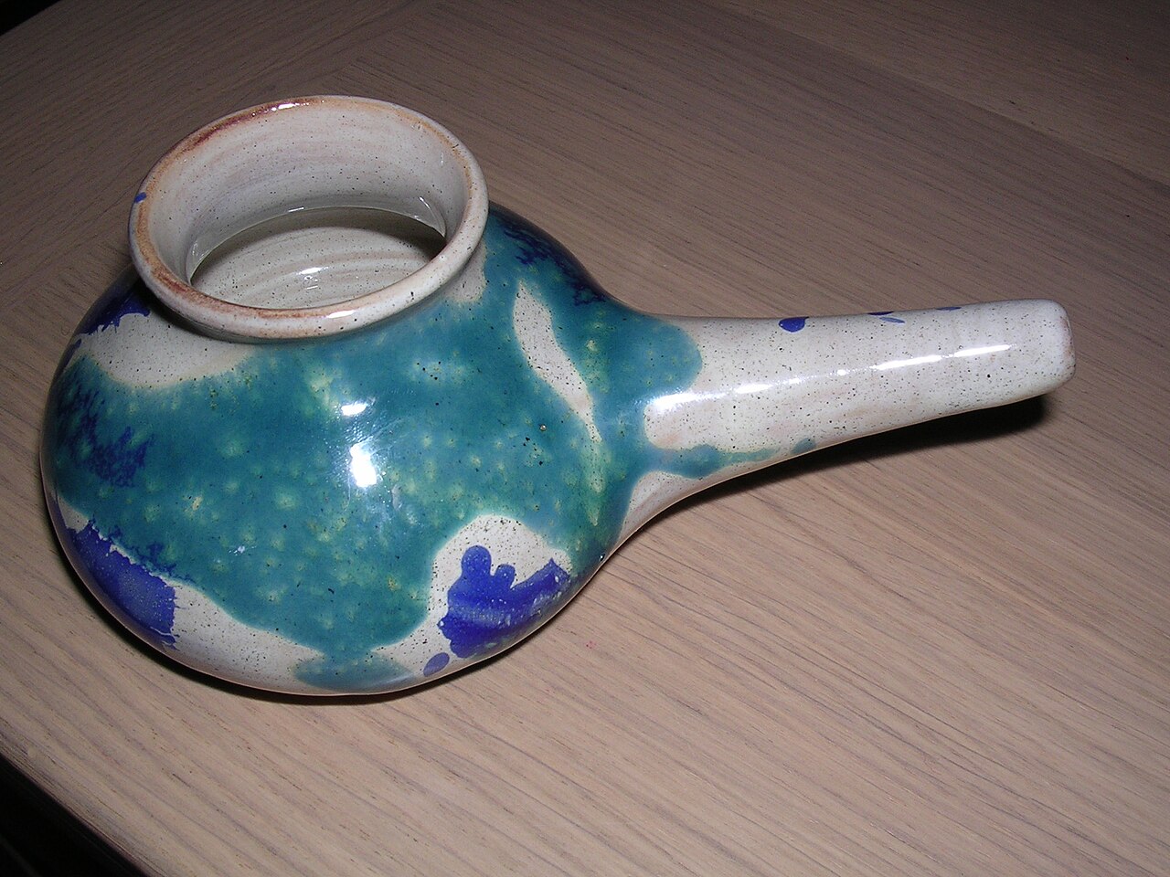 A ceramic neti pot for saline nasal rinsing