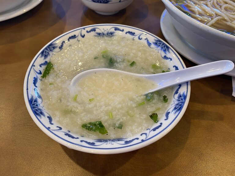 A bowl of plain rice congee with a spoon