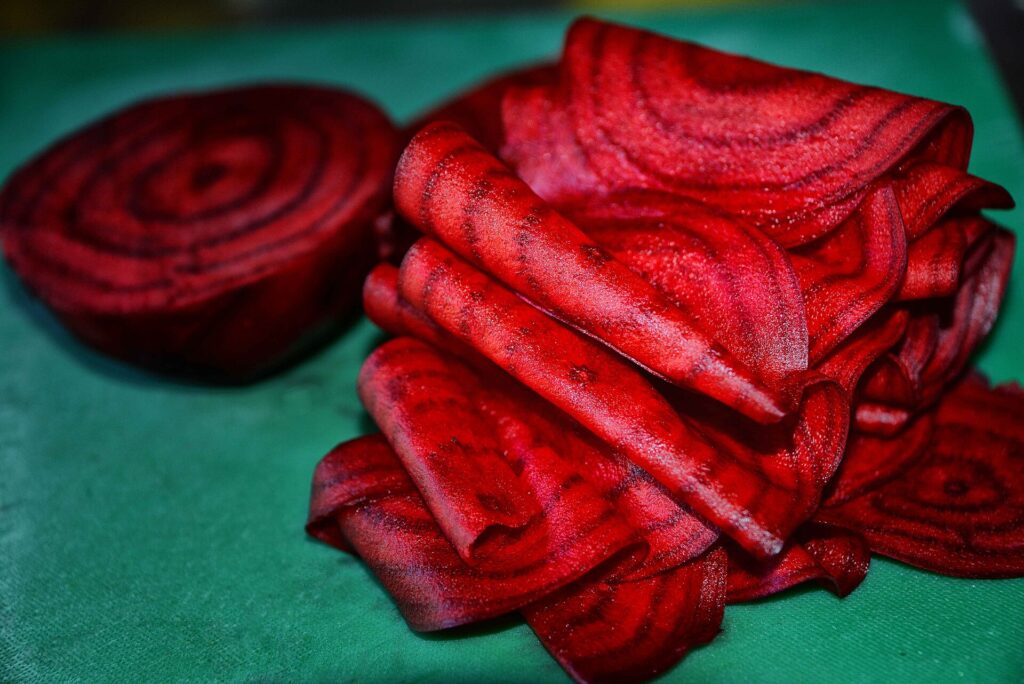 Thin slices of deep red beetroot on a plate