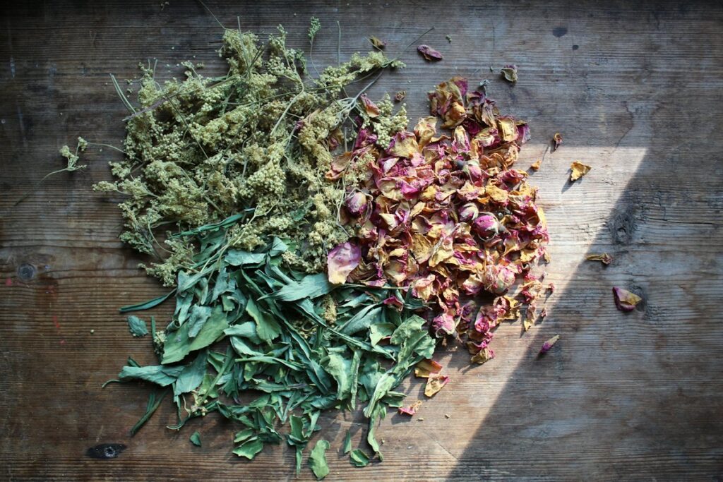 Dried herbs and rose petals on a wooden table