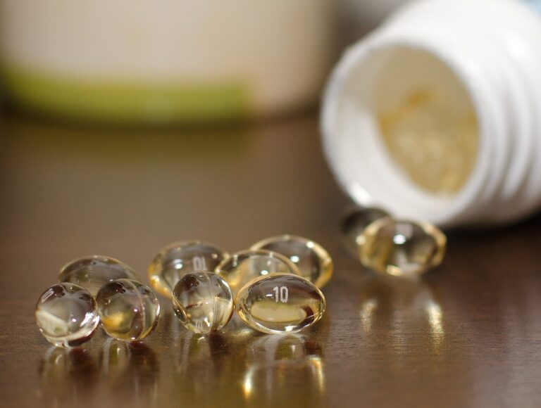 Clear golden softgel capsules spilling from a supplement bottle